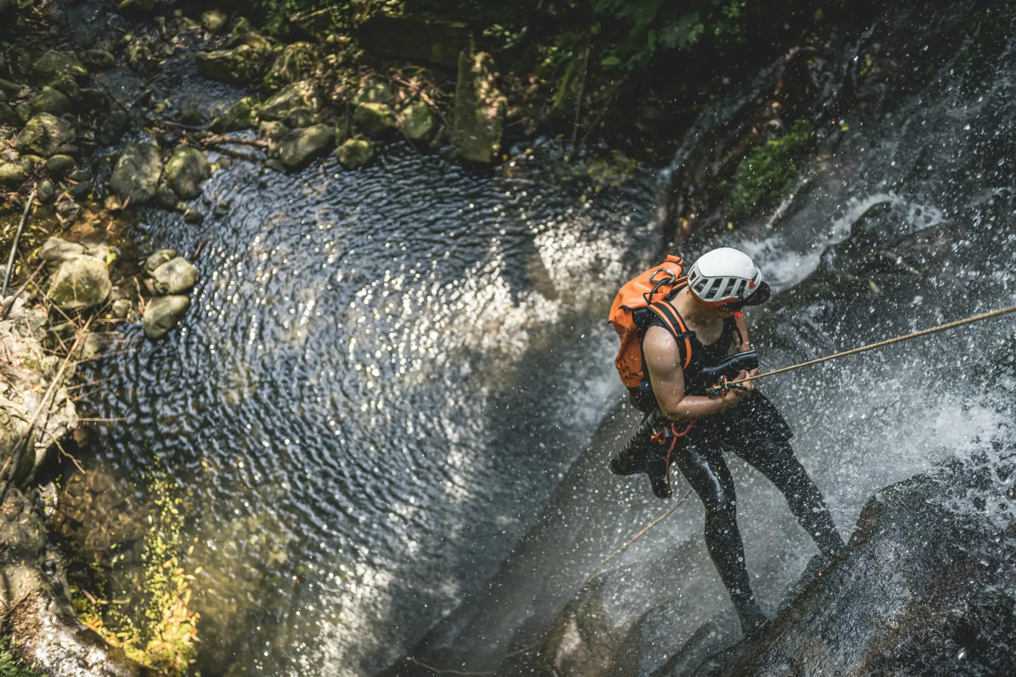 Canyoner abseiling down a waterfall